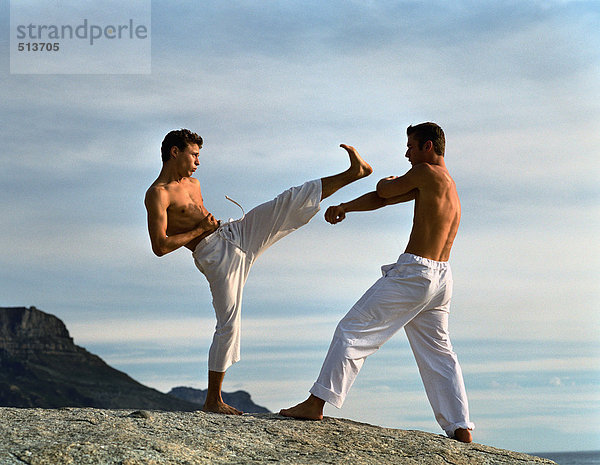 Zwei Männer  die Kampfsport treiben  einer verteidigt  einer greift an.