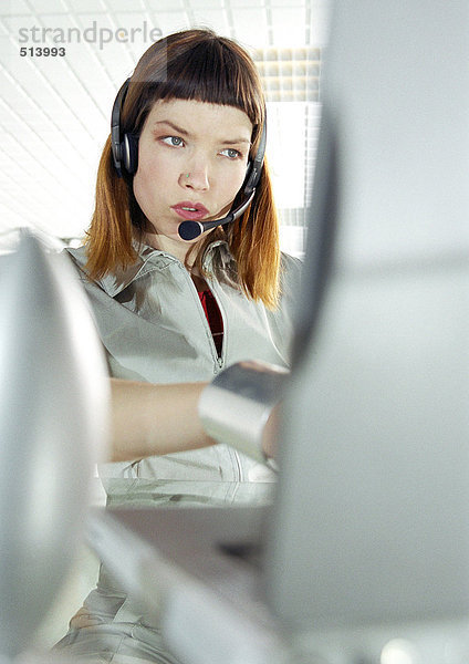 Frau am Schreibtisch mit Headset
