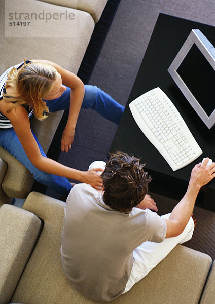 Mann und Frau im Wohnzimmer sitzend am Computer  hohe Blickwinkel
