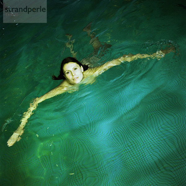 Frau schwimmt im Pool  erhöhte Aussicht