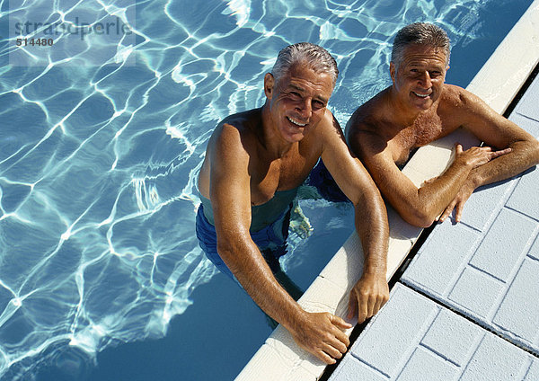 Zwei reife Männer ruhen auf der Seite des Swimmingpools  Portrait  erhöhte Ansicht