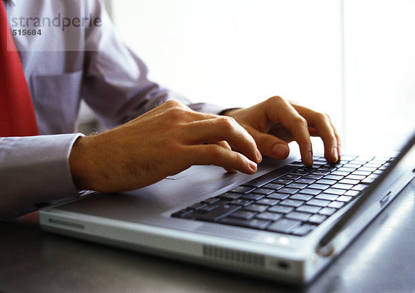 Männerhände auf der Tastatur des Laptops