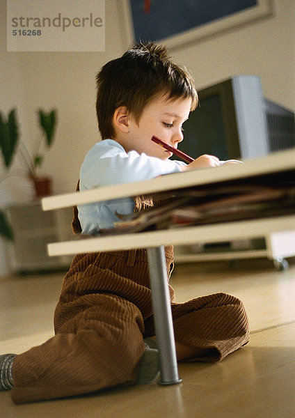 Kleiner Junge auf dem Boden hinter dem Couchtisch sitzend  Zeichnung  in Wohnzimmereinrichtung  kippbar
