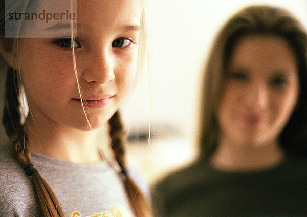 Zwei Mädchen  jüngeres Mädchen im Vordergrund  älteres Mädchen im Hintergrund verschwommen  Portrait