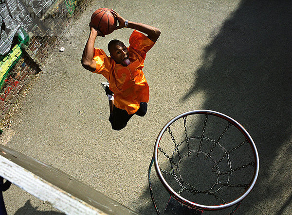Ein Mann  der von oben auf einen Basketball-Dunk schießt.