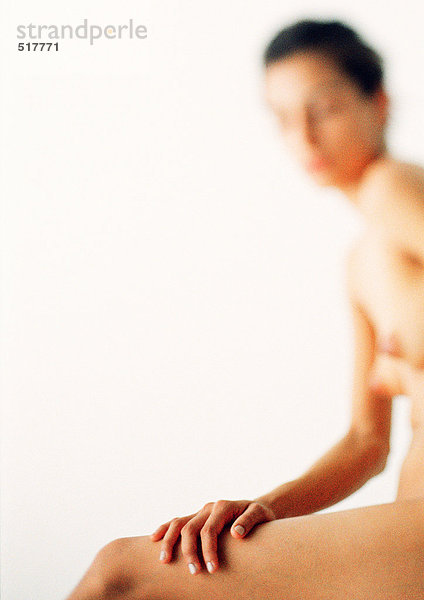 Nackte Frau sitzend  berührender Oberschenkel  selektive Fokussierung