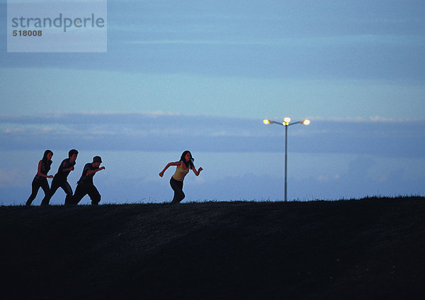 Freunde laufen bei Sonnenuntergang