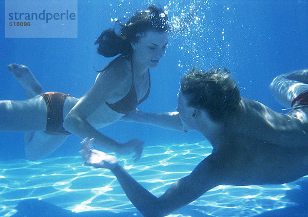 Mann und Frau schwimmen unter Wasser