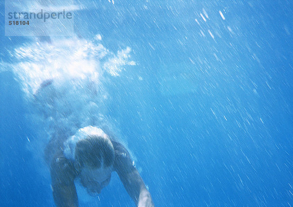 Mann taucht unter Wasser