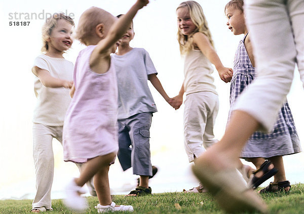 Kinder halten sich an den Händen  gehen im Ring.