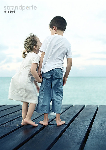 Zwei Kinder stehen auf dem Dock  Rückansicht