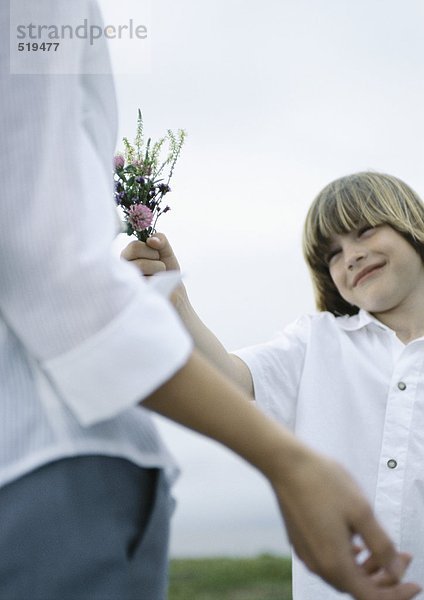 Junge übergebende Frau Blumenstrauß von Wildblumen