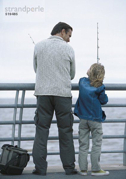 Mann und Sohn beim Angeln am Pier  Rückansicht