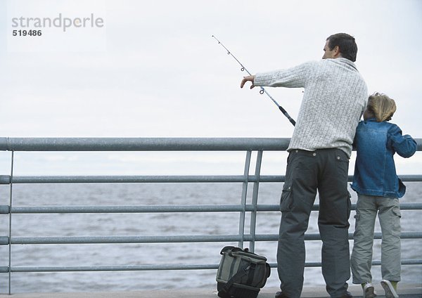 Mann und Sohn fischen am Pier  Mann zeigt  volle Länge