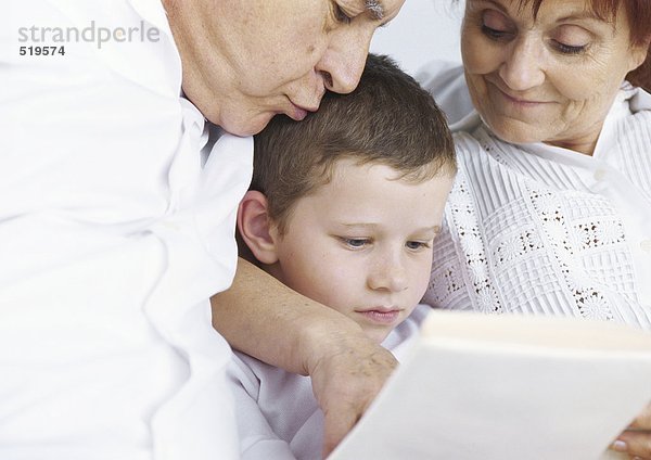 Großeltern beim Lesen mit Enkel