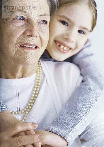 Mädchen umarmt Großmutter  Portrait