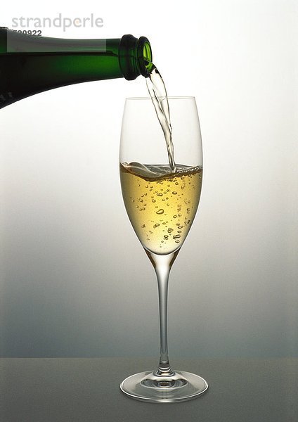 Gießen eines Glases Champagner