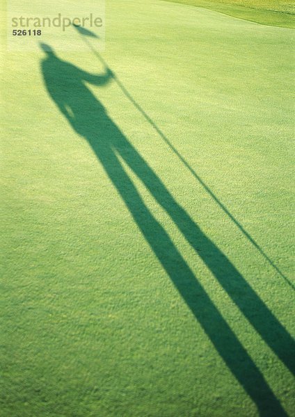 Schatten eines Golfers mit Golfflagge