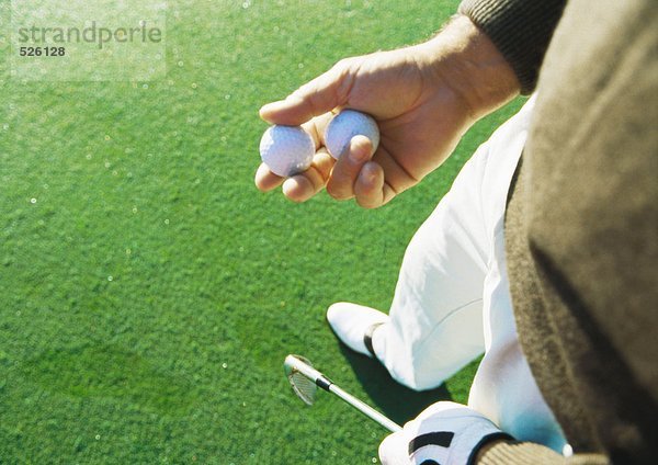 Golfer  der Golfbälle hält  Hochwinkelansicht