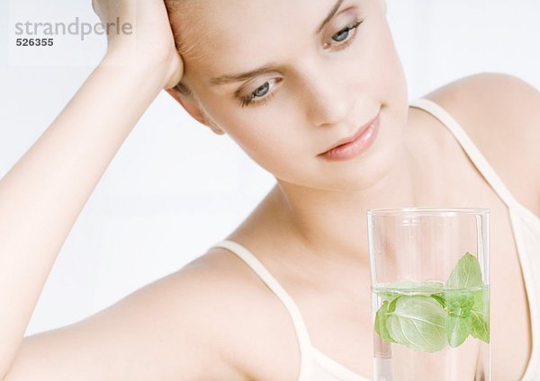 Frau mit einem Glas Kräuterwasser