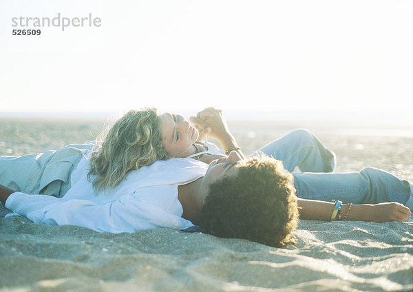 Teenager-Paar am Strand liegend