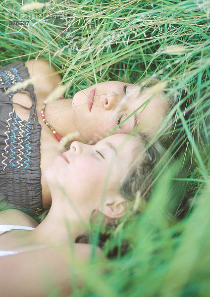 Zwei Mädchen schlafen im Gras