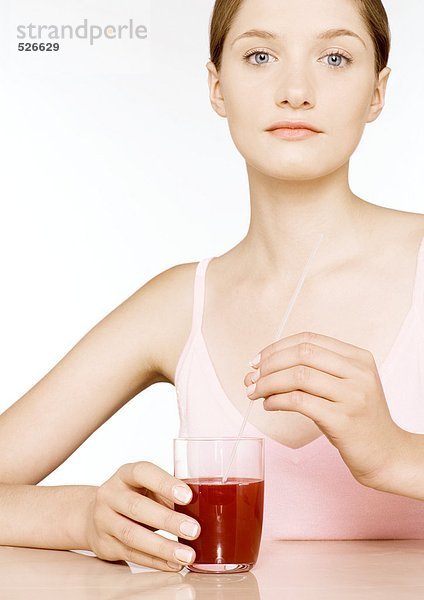 Junge Frau mit einem Glas rotem Saft