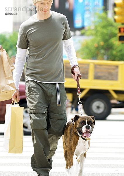 Junger Mann mit Einkaufstasche und Wanderhund