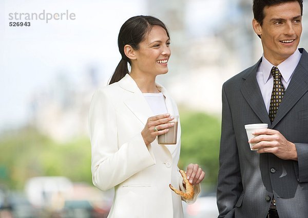 Geschäftsfrau und Mann im Stehen  Kaffee trinken im Freien