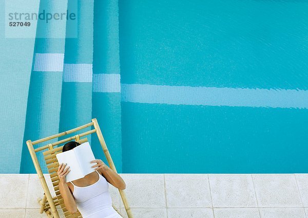 Frau im Sessel am Pool sitzend  Lesung  Hochwinkelblick