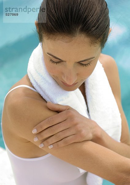 Frau mit Handtuch um den Hals mit Blick auf den Arm