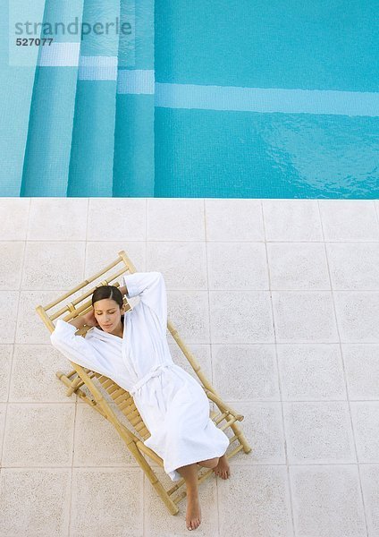 Frau im Sessel am Pool  Blick in den hohen Winkel