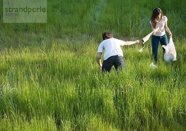 Junges Paar sammelt Wurf auf dem Feld ein