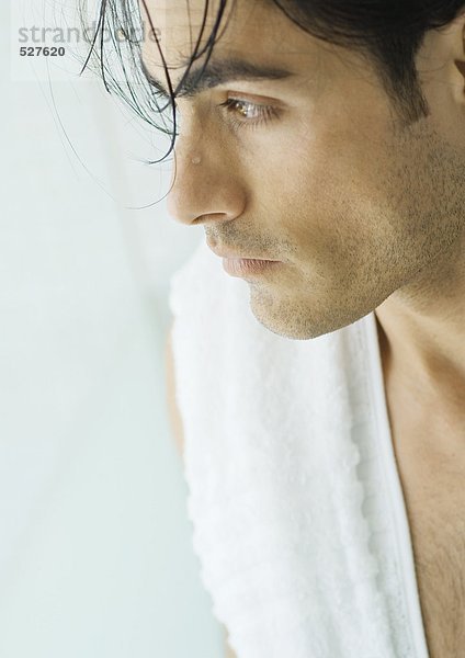 Mann mit nassem Haar und Handtuch über der Schulter