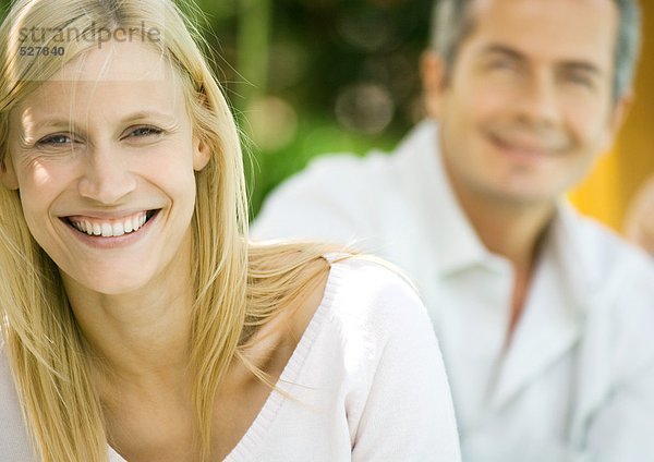 Frau lächelnd  Mann im Hintergrund  Portrait
