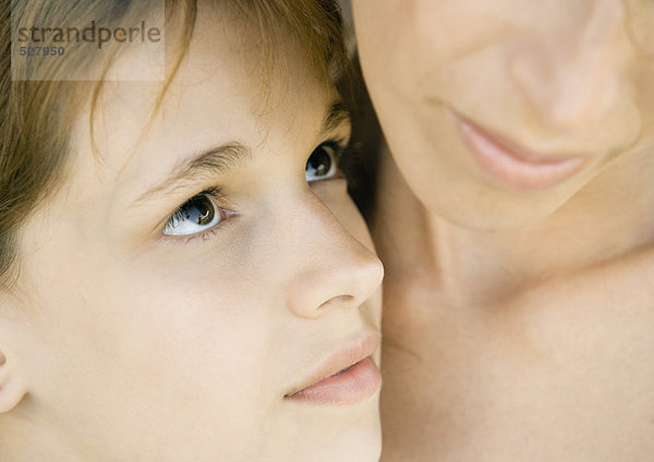 Mutter umarmt ihre Tochter  Mädchen schaut sie mit Liebe an  extreme Nahaufnahme