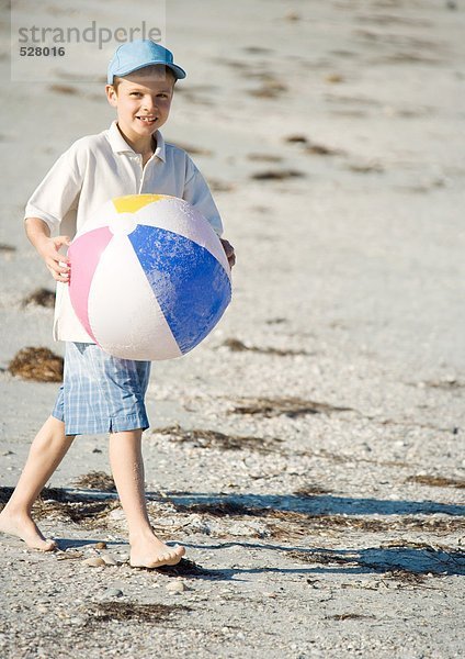 Junge mit Strandball am Strand