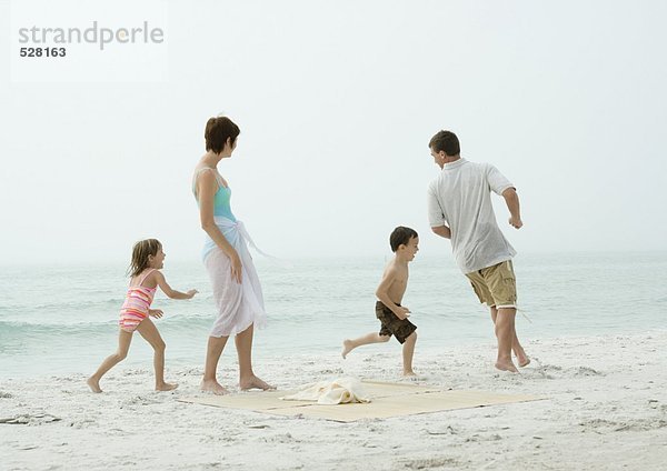 Familie beim Spielen am Strand