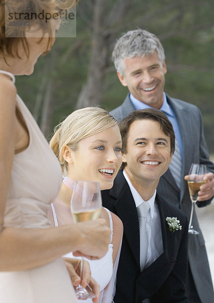 Freiluft-Hochzeitsfeier  junge Braut und Fellpflege zwischen Mann und Frau