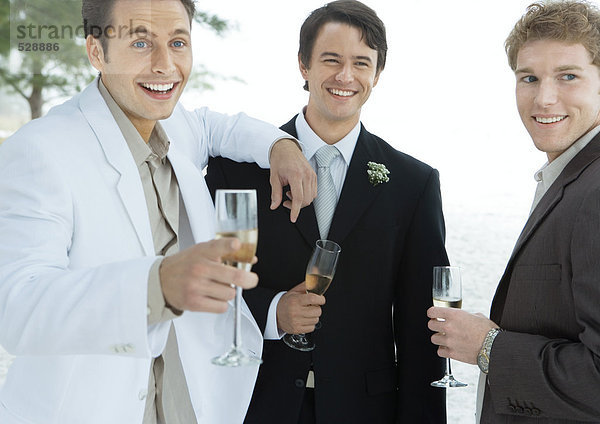 Bräutigam stehend mit zwei männlichen Freunden