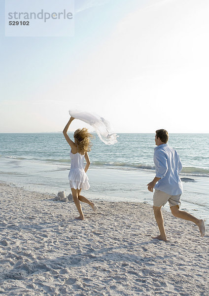 Frisch verheiratet  Mann jagt Frau am Strand