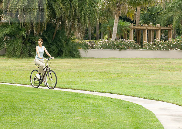 Frau mit dem Fahrrad auf dem Gehweg