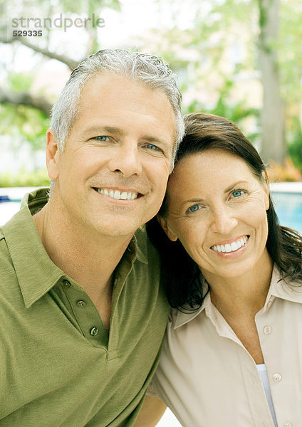 Erwachsenes Paar lächelnd  Portrait  Pool im Hintergrund