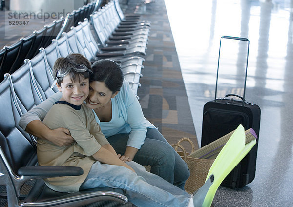 Frau sitzend mit Sohn in der Flughafenlounge