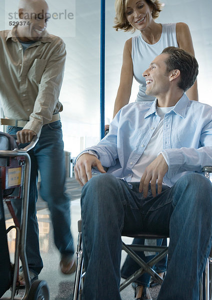 Mann im Rollstuhl im Gespräch mit Freunden