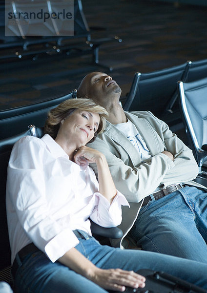 Reisende schlafen in der Flughafenlounge