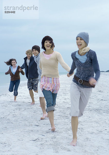 Junge Erwachsene beim Laufen am Strand