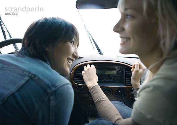 Zwei junge erwachsene Freundinnen im Auto zusammen
