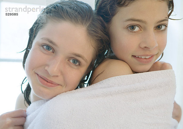 Zwei Mädchen teilen sich ein Handtuch.