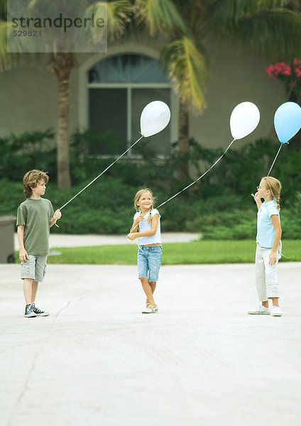 Vorstadtkinder mit Luftballons